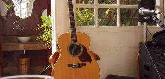 guitare posée contre une porte fenêtre