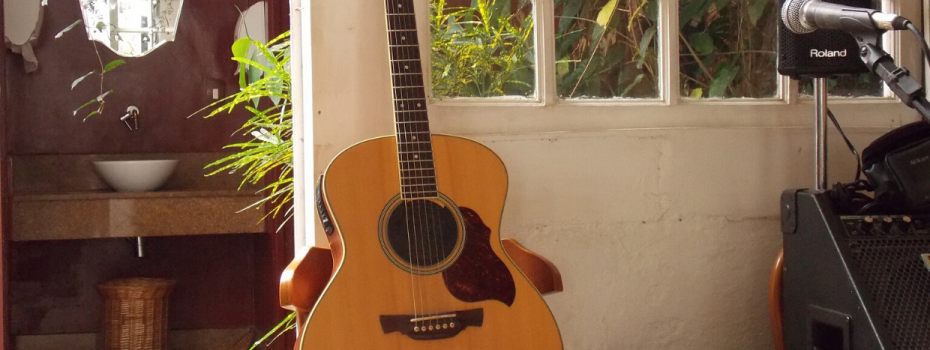 guitare posée contre une porte fenêtre