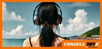 Personne de dos, face à la mer, avec un casque de musique sur les oreilles.